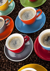 bunte espresso tassen auf kaffeebohnen