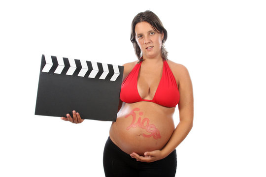 pregnant woman with beautiful belly holding movie clacket