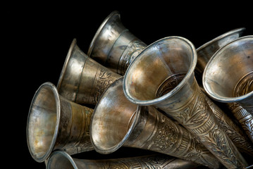 Closeup of metal horns tilted upwards on black background.