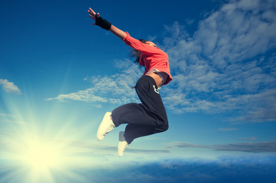 Sport Woman Jumping And Fly Over Sky And Sun