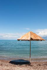 Greek beach with straw parasol