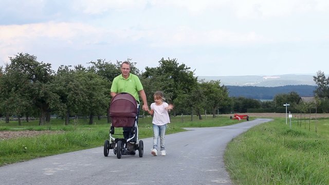Vater mit Kind und Kinderwagen