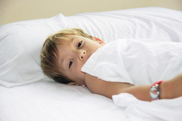 young boy laying in bed