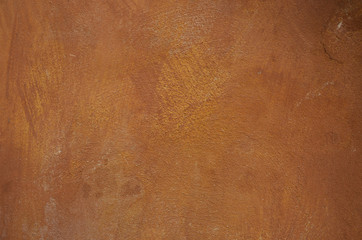 Stained orange plaster wall with rust