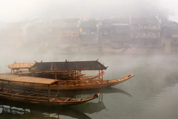 Fotobehang China river landscape with boats and traditional architecture © raywoo