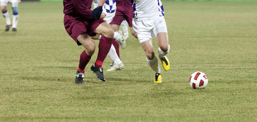 Soccer players running after the ball