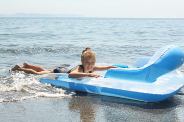 Girl on  inflatable mattress in sea