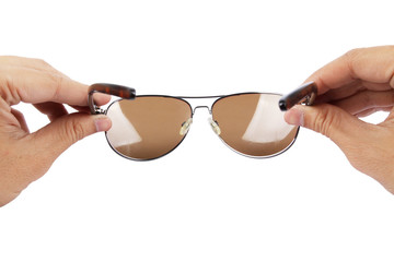 A Man holding aviator sunglasses about to wear.