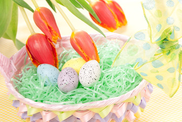 Easter spring eggs in basket and tulip flowers