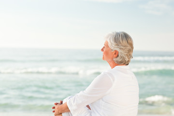 Fototapeta na wymiar Woman who is sitting on the beach