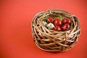 Fototapeta na wymiar Easter eggs in wicker basket on red background