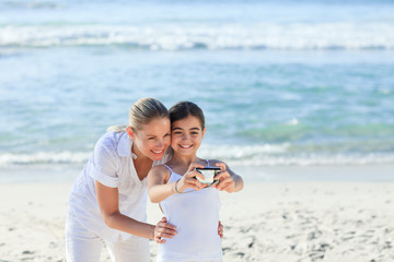 Little girl taking a photo of herself and her mother