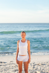 Woman practicing yoga on the beach