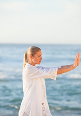 Woman practicing yoga on the beach