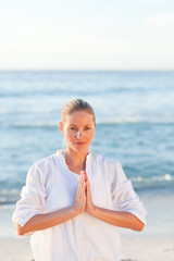 Fototapeta na wymiar Woman practicing yoga at the beach