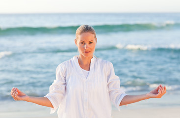 Fototapeta na wymiar Active woman practicing yoga on the beach