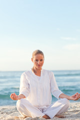 Fototapeta na wymiar Active woman practicing yoga on the beach