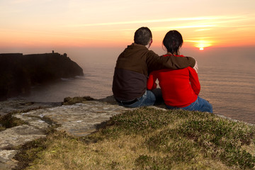 Fototapeta na wymiar Loving Couple at sunset on irish Cliffs of Moher