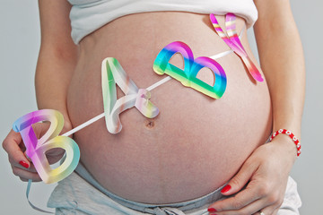 pregnant woman's belly with baby written on it