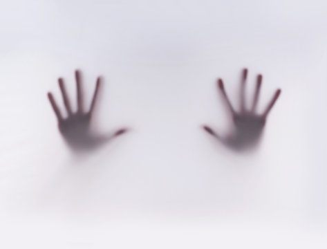 Hands of a young woman on a gray and foggy background