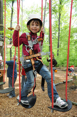 Kind klettert im Waldseilgarten