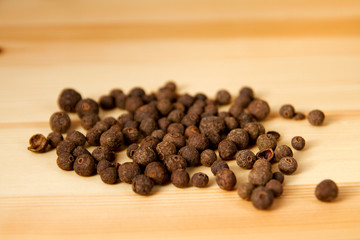 Fragrant peppercorns on wooden surface