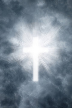 Religious cross shining through clouds