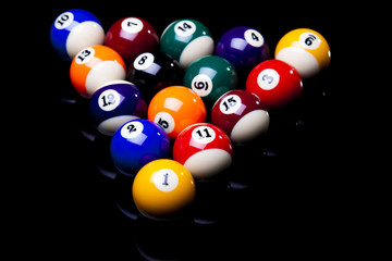 Billiard balls, cue on black table