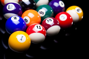 Billiard balls, cue on black table