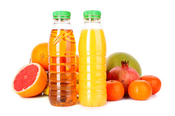 bottles of juice  with ripe fruits on white background