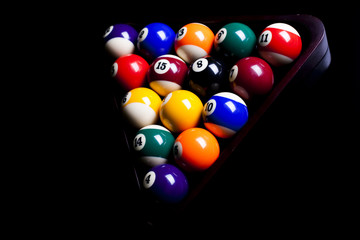 Billiard balls, cue on black table