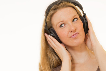 Fototapeta premium Junge Frau hört Musik mit Kopfhörer