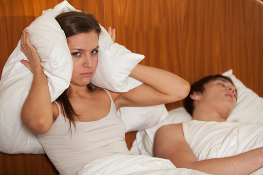 Unhappy woman and her snoring husband.