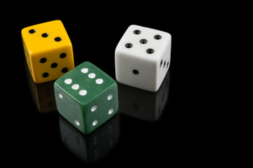 Green, yellow and white dices on black background