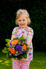 Kind mit Blumenstrauß. Geschenk für Muttertag
