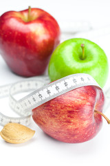 apple, nuts and measure  tape isolated on white