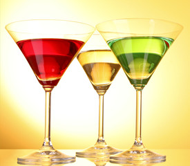 a few glasses of alcoholic drinks in a yellow-brown background