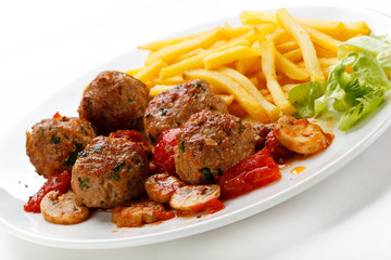 Roasted meatballs, French fries and vegetables