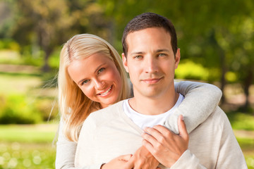 Obraz premium Woman hugging her boyfriend in the park