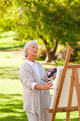 Fototapeta premium Senior woman painting in the park