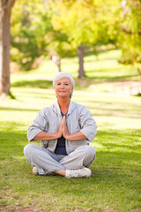 Mature woman practicing yoga in the park