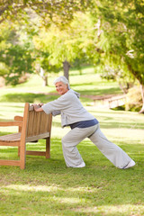 Fototapeta premium Senior woman doing her stretches in the park