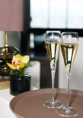 Two flutes of champagne on restaurant table