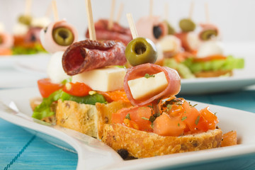 Bruschetta with prosciutto, olive, cheese and tomato