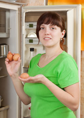 woman putting fresh eggs into refrigerator