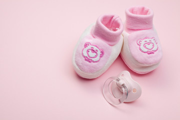 pink baby shoes and pacifier