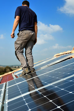 Homme qui installe des panneaux solaires