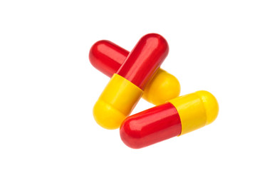 Three red yellow capsules over white