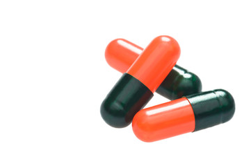Three red black capsules over white