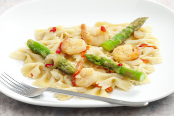 hot pasta farfalle with asparagus and prawns